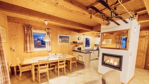 A cozy wooden interior with a dining area, kitchen, and fireplace. - 034 W14 in St Georgen am Kreischberg (Sankt Georgen am Kreischberg)