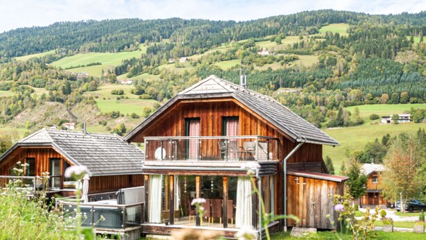 A wooden chalet with a balcony, surrounded by lush greenery and a hilly landscape. - 033 W13 in St Georgen am Kreischberg (Sankt Georgen am Kreischberg)