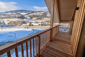 A wooden balcony with a view of a snowy landscape and buildings in the distance. - 038 W17 in St Georgen am Kreischberg (Sankt Georgen am Kreischberg)