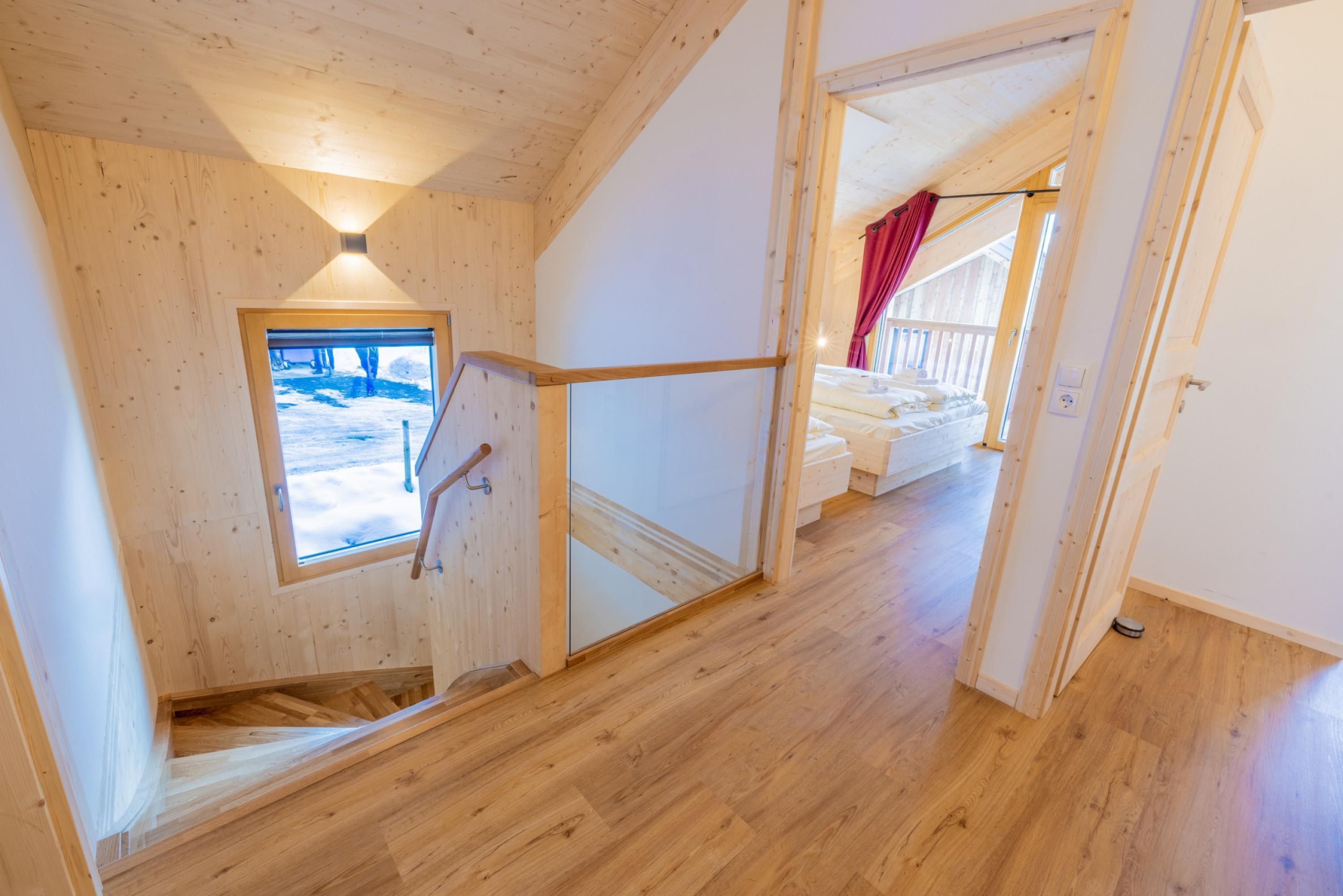 A wooden interior with a staircase leading to a bedroom.