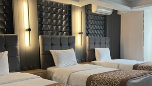 A hotel room with three beds, a modern design, and a large window. - Hotel Eronur (Bilecik)