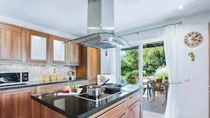 Une cuisine moderne avec des meubles en bois, un plan de travail noir et un grand îlot central.