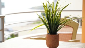 A potted plant on a balcony table with a chair in the background. - Saranda Waterside Apartments (Sarandë)