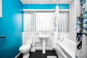A bathroom with a toilet, sink, and bathtub.