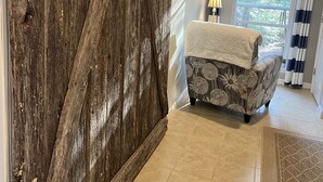 A room with a rustic wooden wardrobe, a patterned armchair, a lamp, and a view of trees through a window. - NEW! On a WATERFALL! Fiery Gizzard Lodge at Sycamore Falls! 13 bluff acres!  (Tracy City)