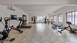 Ein Fitnessstudio mit Laufbändern, Kraftgeräten und Trainingsmatten.