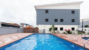 Ein Schwimmbecken mit einem modernen Gebäude im Hintergrund.