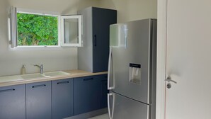 Une cuisine moderne équipée d’un réfrigérateur en acier inoxydable, d’un évier avec un robinet et de placards.