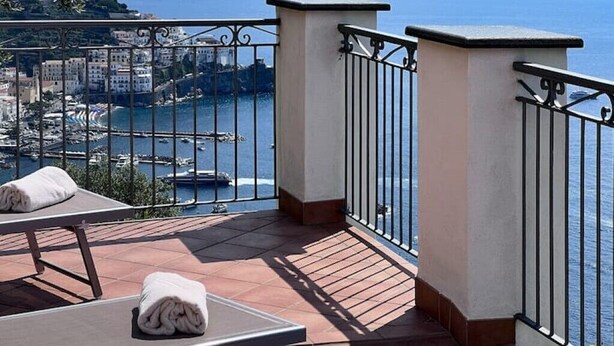 Un balcon avec vue sur la mer et les bâtiments.