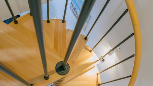 A spiral staircase with wooden steps and metal railings.