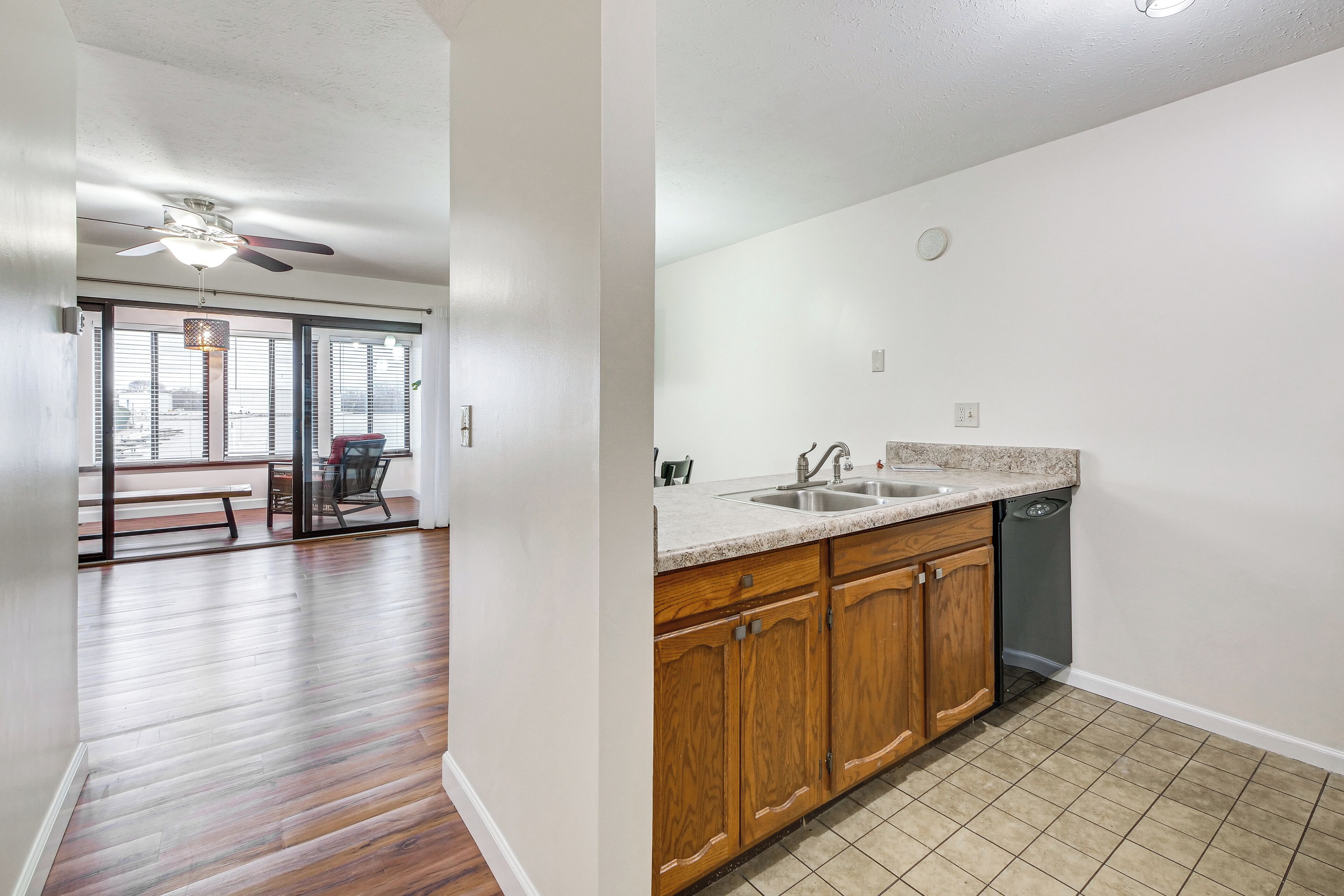 A kitchen with wooden cabinets, a granite countertop, and a dishwasher.