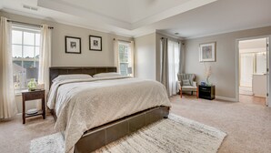 A bedroom with a large bed, a nightstand, a chair, and a door leading to another room. - Pet-friendly Atlanta Home: 9 Mi to Downtown! (Atlanta)