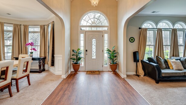 A spacious entryway with a wooden floor, a chandelier, and a large arched window. - Pet-friendly Atlanta Home: 9 Mi to Downtown! (Atlanta)