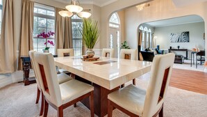 A spacious dining area with a large marble table, six chairs, and a potted plant. - Pet-friendly Atlanta Home: 9 Mi to Downtown! (Atlanta)