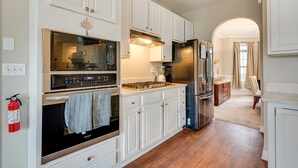 A modern kitchen with white cabinetry, stainless steel appliances, and a wooden floor. - Pet-friendly Atlanta Home: 9 Mi to Downtown! (Atlanta)