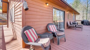 A wooden deck with wicker chairs and a grill. - Pet-friendly Hiawassee Cabin w/ Lake Views & Sauna (Hiawassee)
