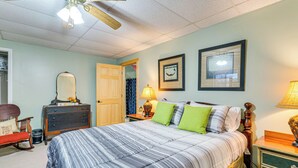 A bedroom with a large bed, a dresser, a rocking chair, and a ceiling fan. - Pet-friendly Hiawassee Cabin w/ Lake Views & Sauna (Hiawassee)
