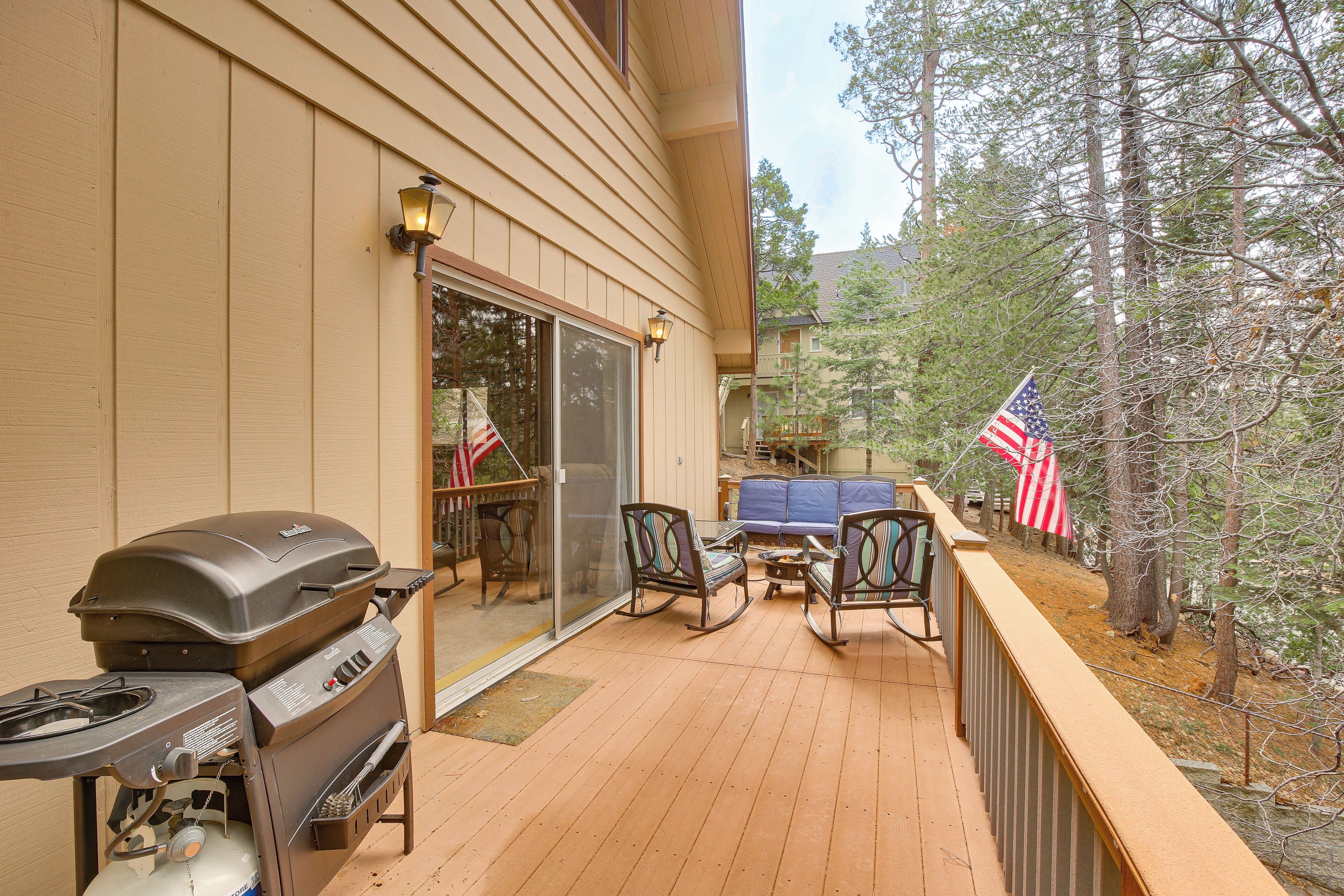 Une terrasse avec un barbecue, du mobilier d’extérieur et des drapeaux américains.