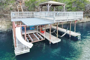 A wooden dock with a covered upper deck and a ladder leading to it. - Newly Remodeled Lakefront Granbury Escape w/ Dock! (Granbury)