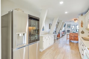 A spacious kitchen with a stainless steel refrigerator, white cabinetry, and a wooden island. - Newly Remodeled Lakefront Granbury Escape w/ Dock! (Granbury)