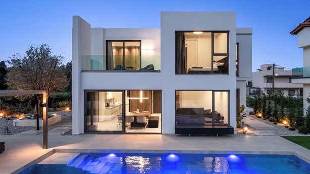 A modern two-story house with a swimming pool, large windows, and a well-lit interior. - Casa Yiava with private pool (Ialysos, Dodecanese)