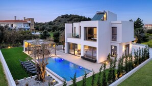 A modern two-story house with a swimming pool, outdoor seating, and a view of the surrounding landscape. - Casa Yiava with private pool (Ialysos, Dodecanese)