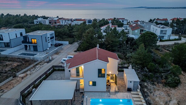 A modern residential area with a house featuring a swimming pool, a covered patio, and a view of the sea. - Villa Kristina (Nin)