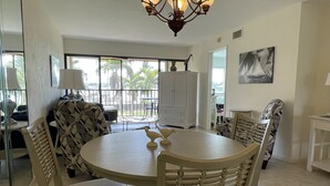 A dining area with a round table, four chairs, a chandelier, and a view of the outdoors. - Great view, great location, piece of paradise......just perfect!   (Marco Island)