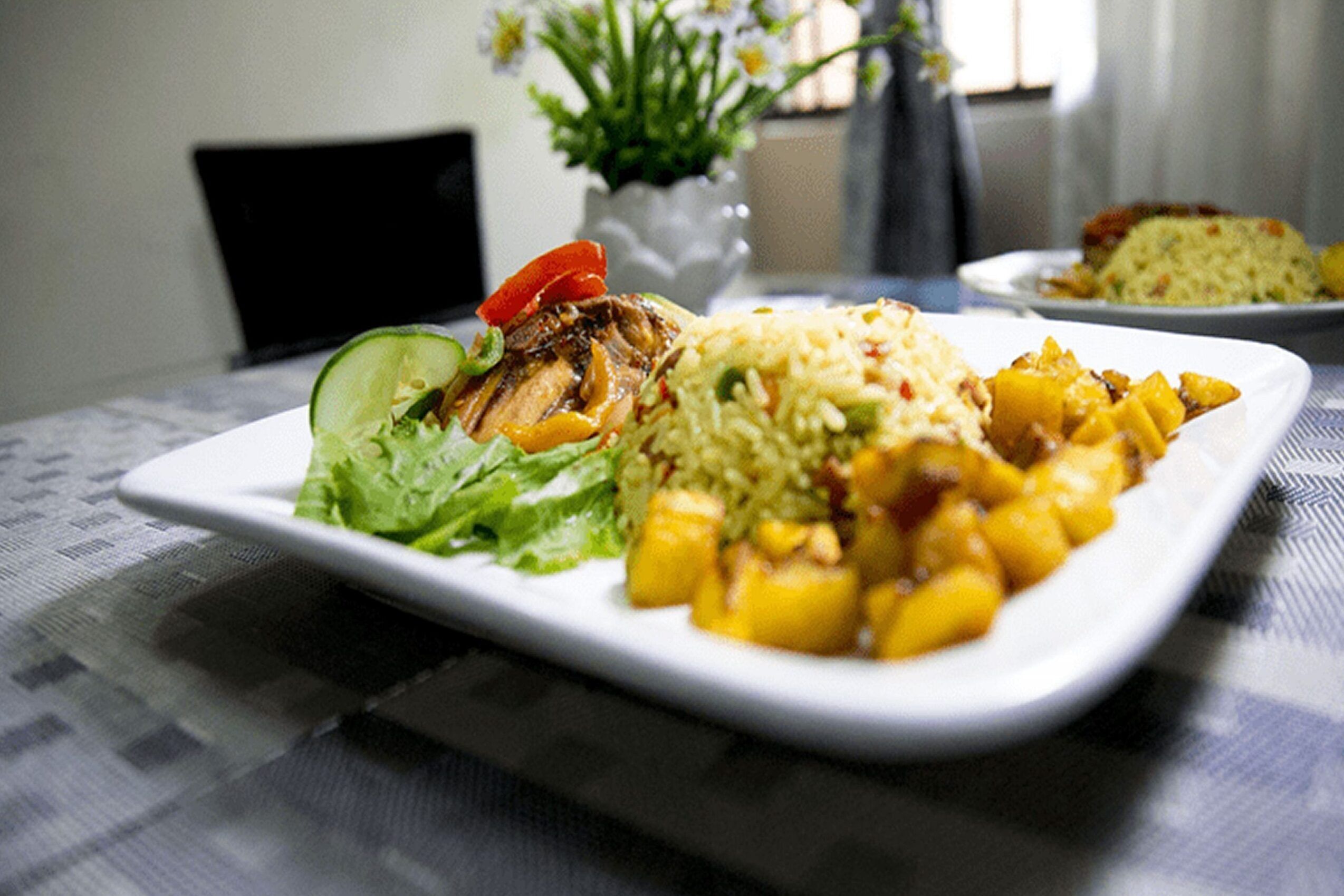Une assiette de nourriture composée de riz, de légumes et d’un morceau de viande grillée.