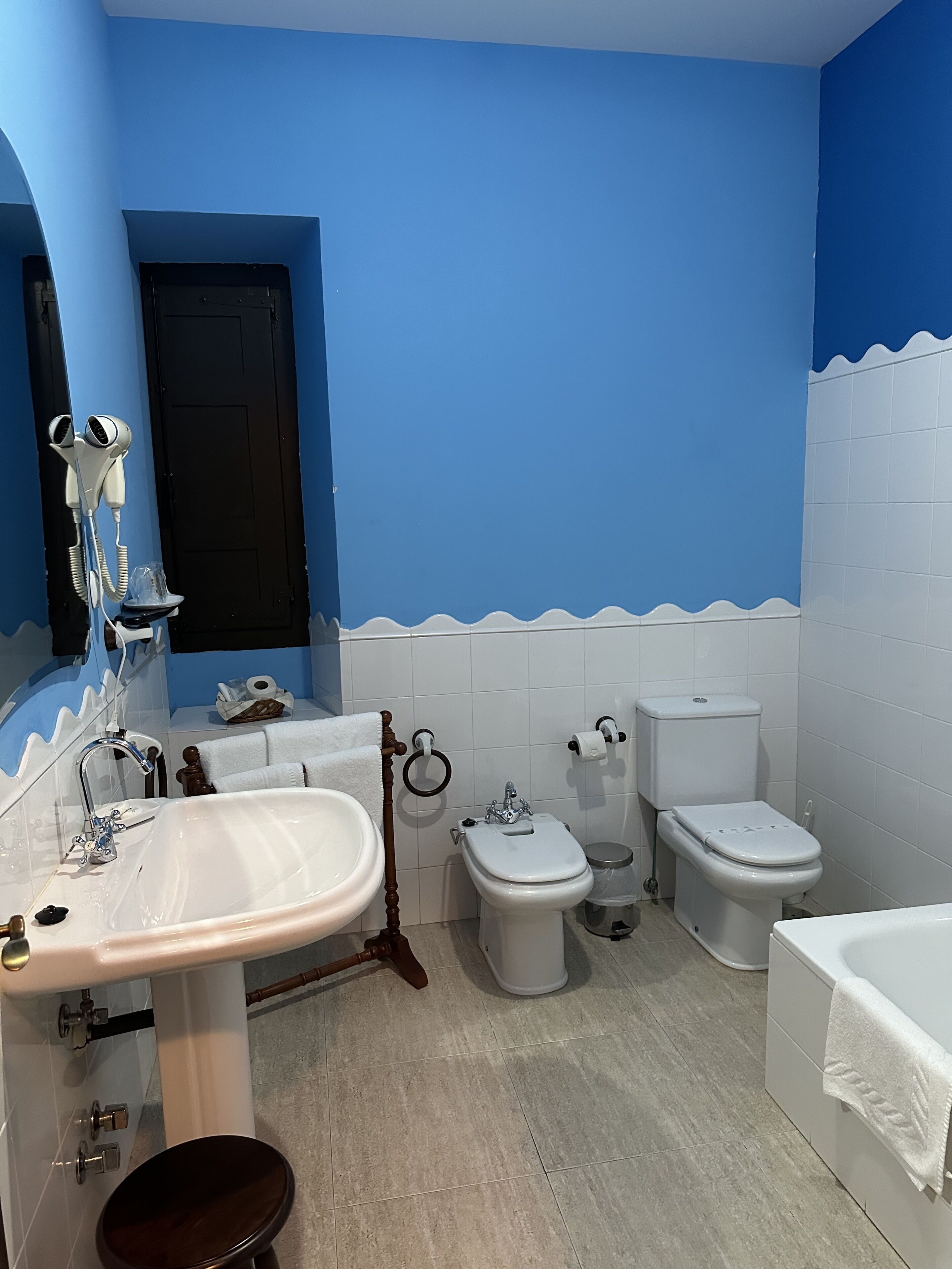 A bathroom with a sink, bidet, toilet, and bathtub.