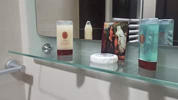 Ein Badezimmerschrank mit Pflegeprodukten, einem kleinen weißen Behälter und einem gerahmten Bild.