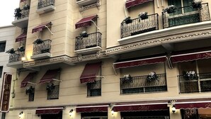 A multi-story hotel with balconies, awnings, and a sign indicating it is a hotel. - Hotel St Telemly (Algiers)