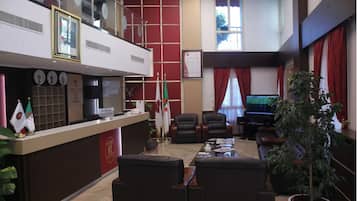 A reception area with a counter, flags, and seating.