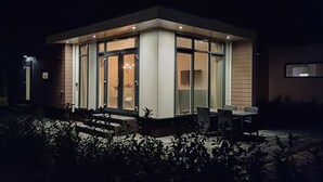 Un edificio moderno y bien iluminado con grandes ventanales y una zona de estar al aire libre.