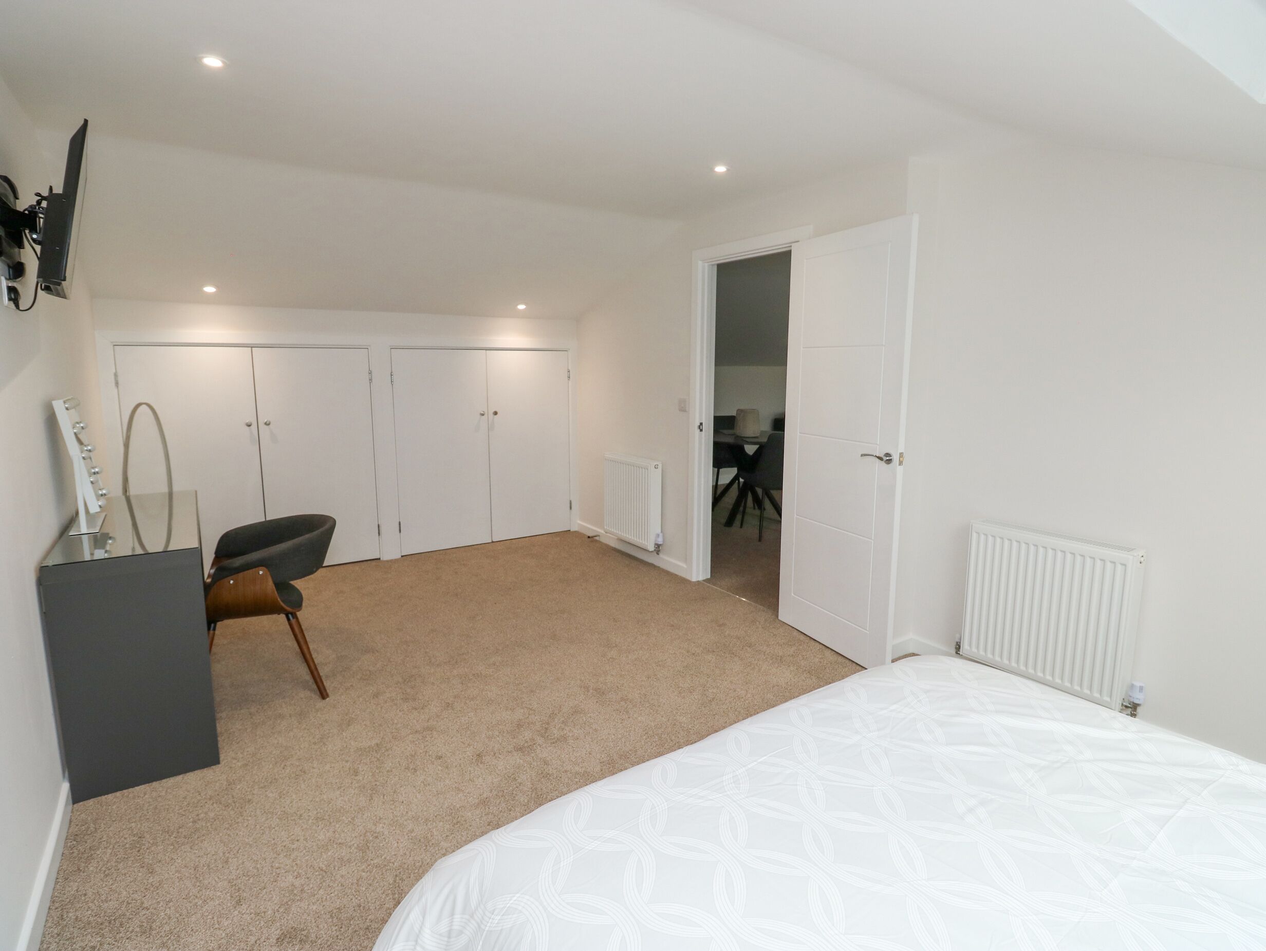 Une chambre à coucher avec un lit, une chaise, un bureau et une armoire.