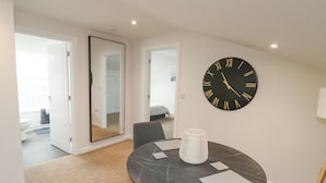 Une pièce moderne avec une table ronde en marbre, une grande horloge murale et un miroir.