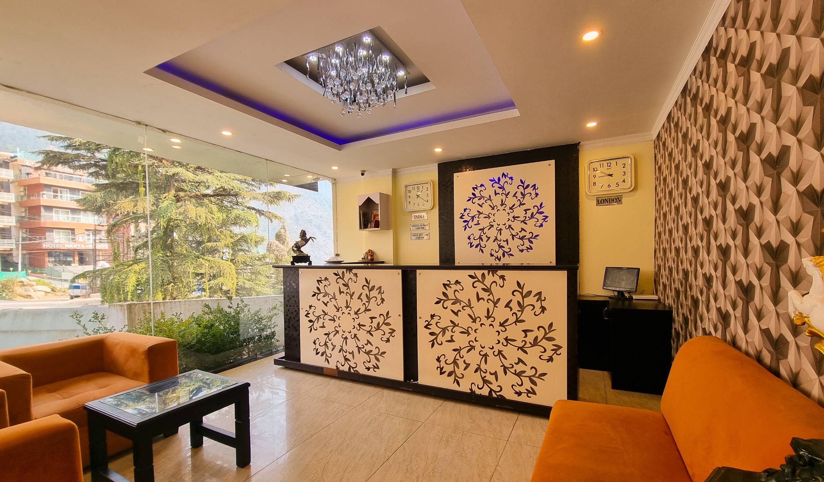A hotel lobby with a reception desk, seating area, and a view of the outside.