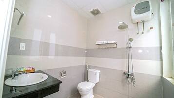 A modern bathroom with a toilet, sink, and shower.