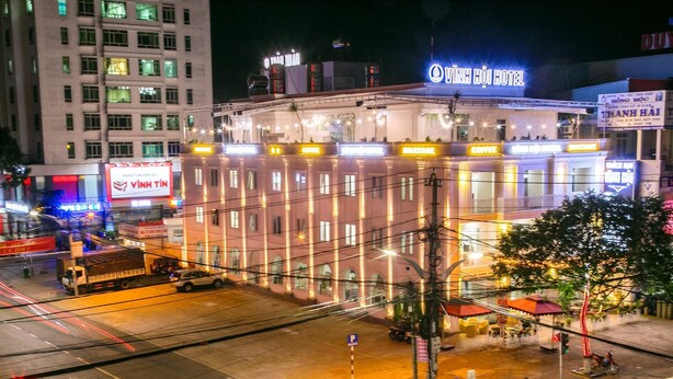 Et hotel med et skilt, der viser "Vinh Hoi Hotel", og en restaurant med navnet "Vinh Hoi".