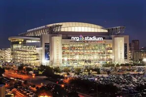 Ein modernes Stadion mit mehreren Sitzstufen und einer großen, beleuchteten Beschilderung mit dem Schriftzug "NRG Stadium".