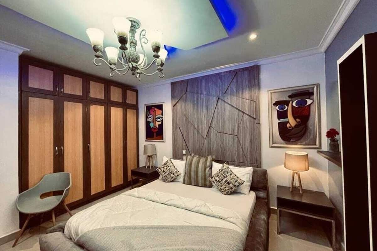 Ein Schlafzimmer mit einem großen Bett, einem Kleiderschrank, einem Schreibtisch und einem Stuhl.