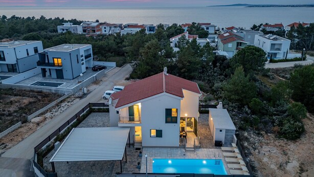A modern residential building with a swimming pool, surrounded by other houses, overlooking a body of water. - Villa Kristina Zadarvillas (Nin)