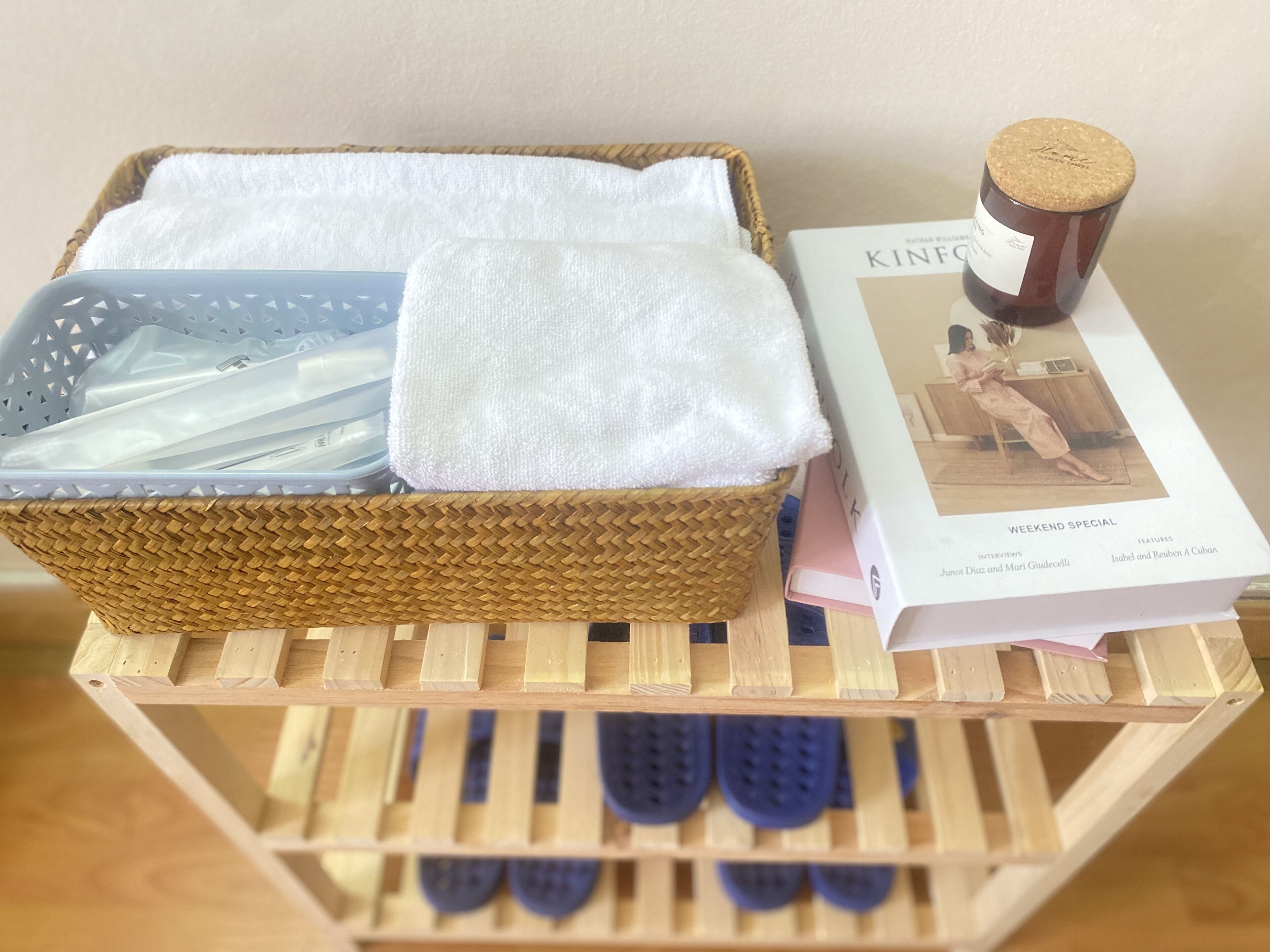 A wicker basket with white towels and a jar of honey on a wooden stand.