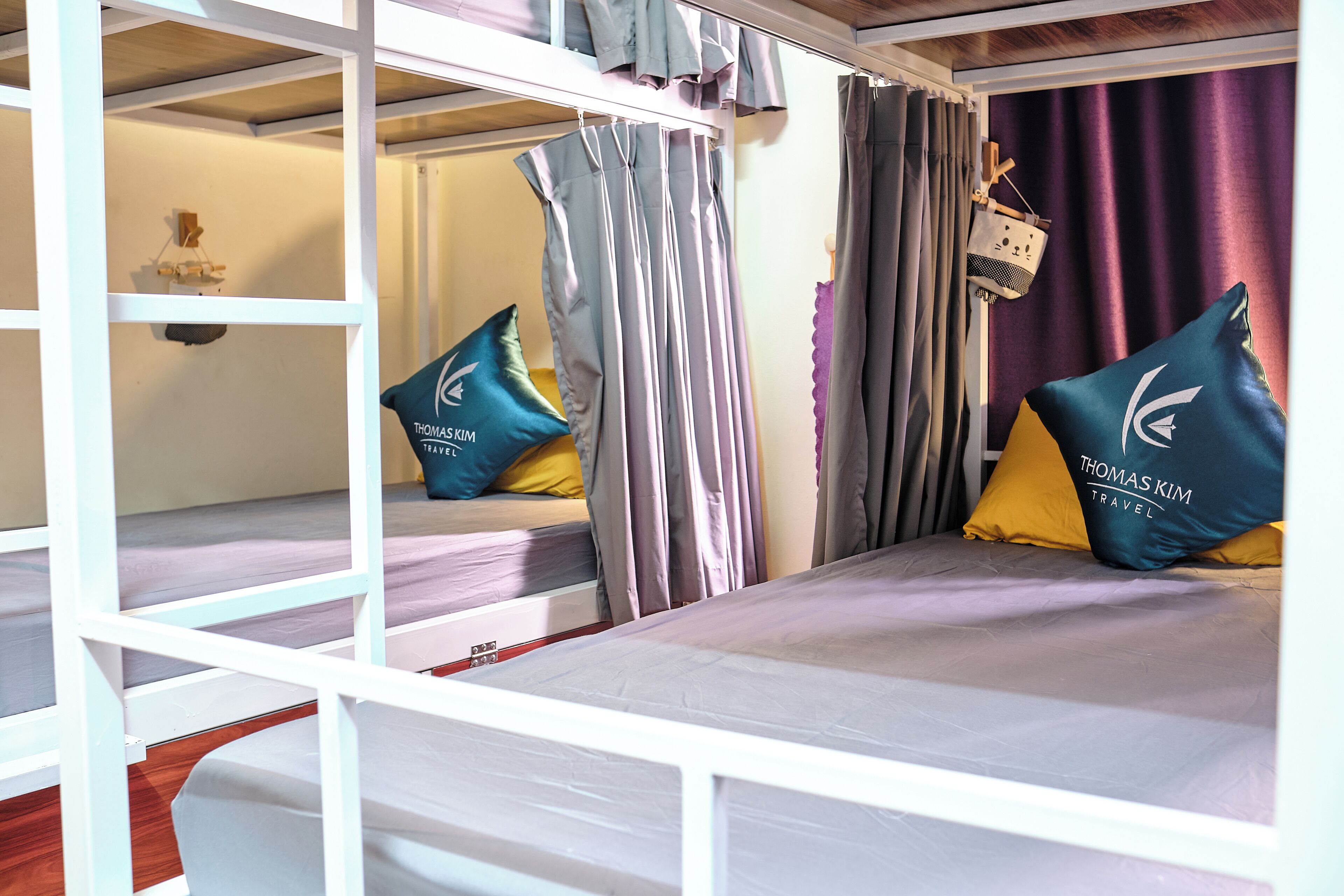 Una cama litera con cabecera, una mesita de noche y una cesta colgante.