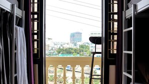 A room with a view of a cityscape through an open window, a balcony railing, and a street lamp. - Kim Homestay & Villa (Bai Chay)
