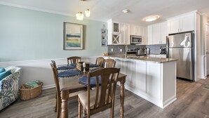 Una cocina moderna con armarios blancos, un refrigerador de acero inoxidable y una isla central.