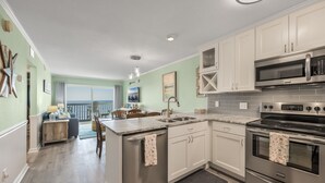 Una cocina moderna con electrodomésticos de acero inoxidable, una isla grande y vistas al exterior.