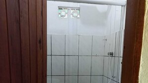 Un baño pequeño y funcional con inodoro, lavabo y zona de ducha.