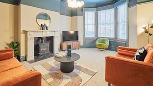 A living room with a fireplace, a television, and a sofa.