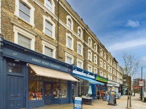 A row of traditional brick buildings with storefronts, including a visible business named 'Abbey Road Framing.' - Bright & Stylish Home by Abbey Road Studios (Greater London)